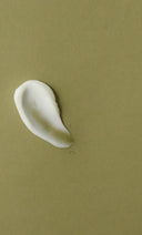 White cream smear on a green background